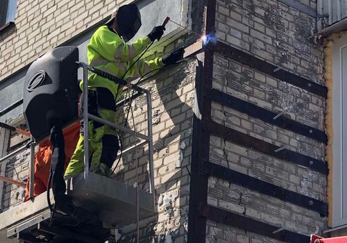 Як у Харкові відновлюють будинок, який було пошкоджено ворожими снарядами (фото)